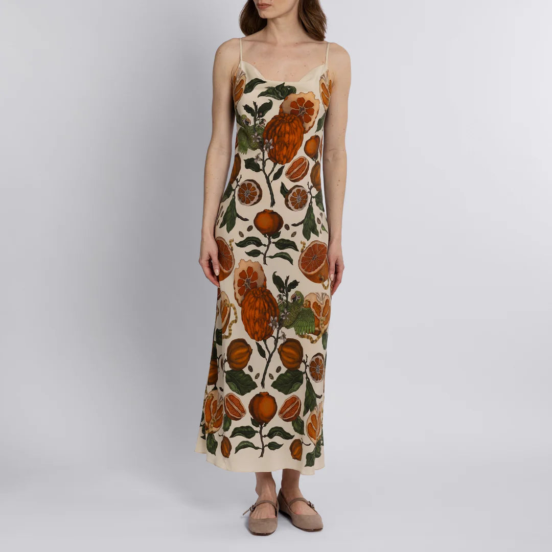 Front view of silk slip dress with citrus fruit and parrot illustration on matte silk crepe