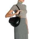Model wearing the Il Bisonte Consuelo Crossbody Bag in black styled as a crossbody with everyday luxury attire