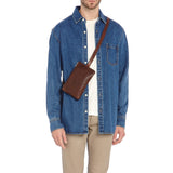 Side angle of the Il Bisonte Duccio Belt Bag in Coffee showing the stud-adjustable strap, zip closure, and full-grain Italian leather texture.