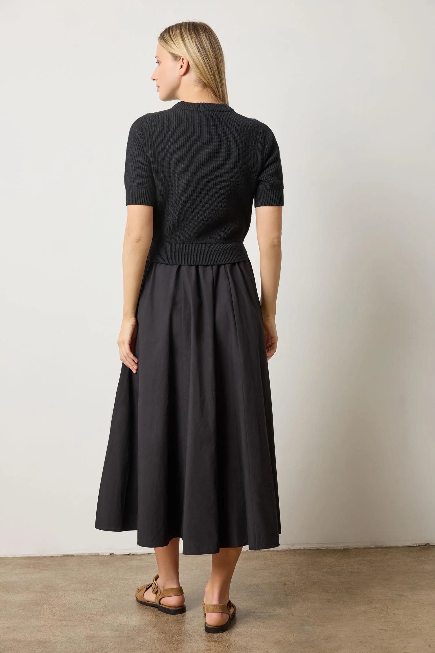 Back view of black mixed media dress – short sleeve knit sweater top and poplin skirt with clean silhouette, curated by CashmereRED Telluride

