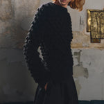 Side or detail view of the Sphere One Buoy M5 sweater in Black showing the hand-knit bobble stitch and airy alpaca construction.