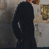 Side or detail view of the Sphere One Buoy M5 sweater in Black showing the hand-knit bobble stitch and airy alpaca construction.