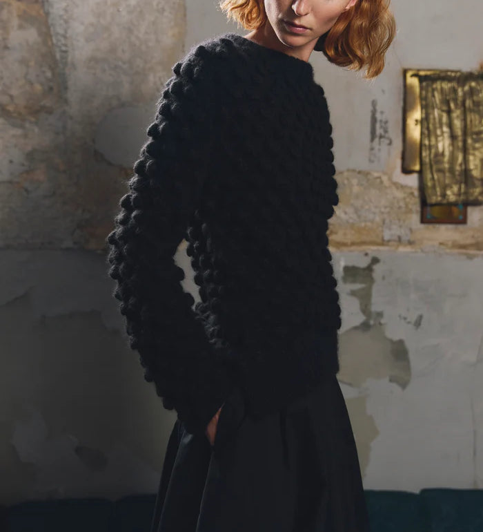 Side or detail view of the Sphere One Buoy M5 sweater in Black showing the hand-knit bobble stitch and airy alpaca construction.