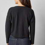 Back view of black cotton waffle knit long sleeve cropped cardigan by Lilla P.

