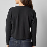 Back view of black cotton waffle knit long sleeve cropped cardigan by Lilla P.


