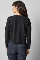 Back view of black cotton waffle knit long sleeve cropped cardigan by Lilla P.

