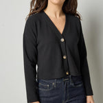 Black cotton waffle knit cardigan with long sleeves and cropped fit by Lilla P, front view.