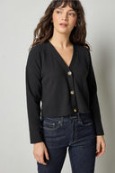 Black cotton waffle knit cardigan with long sleeves and cropped fit by Lilla P, front view.