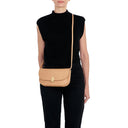 Model carrying the Il Bisonte Atelier clutch bag in natural styled with refined Italian-inspired attire
