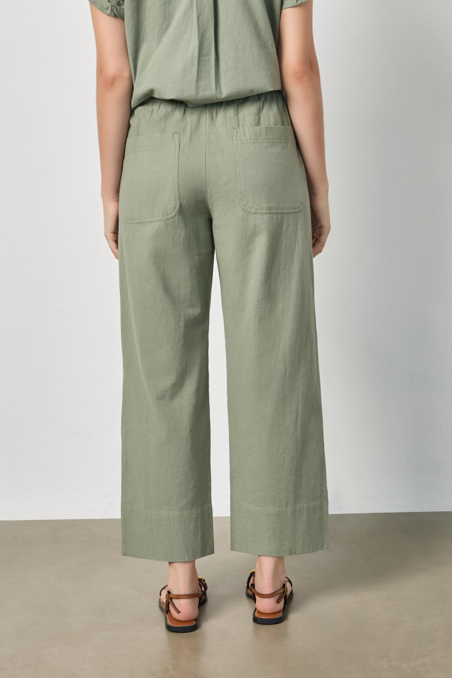 Back view of women's lightweight cotton wide leg pants by Lilla P in sage with ankle length silhouette