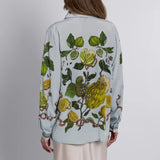 Back view of sand-washed silk oxford shirt in grey-blue with botanical and ribbon illustration

